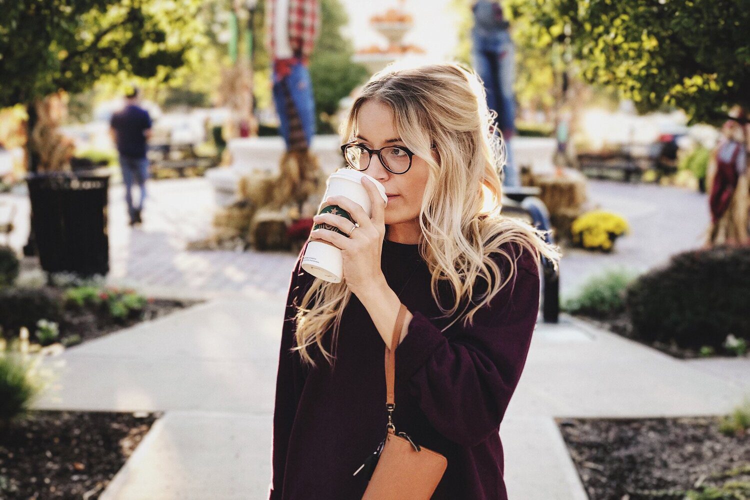 Woman drinking coffee outdoors in autumn