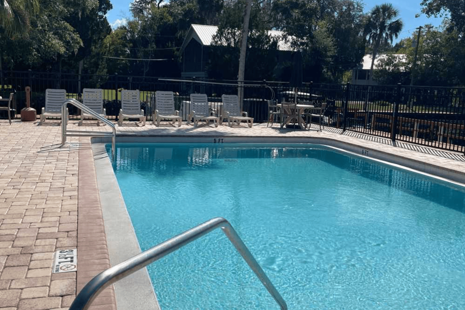 Relaxing pool area with chairs and trees