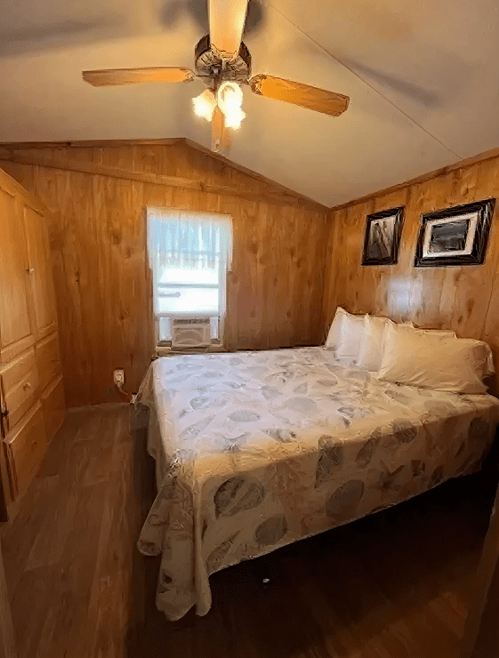 Small bedroom featuring wood paneling and art