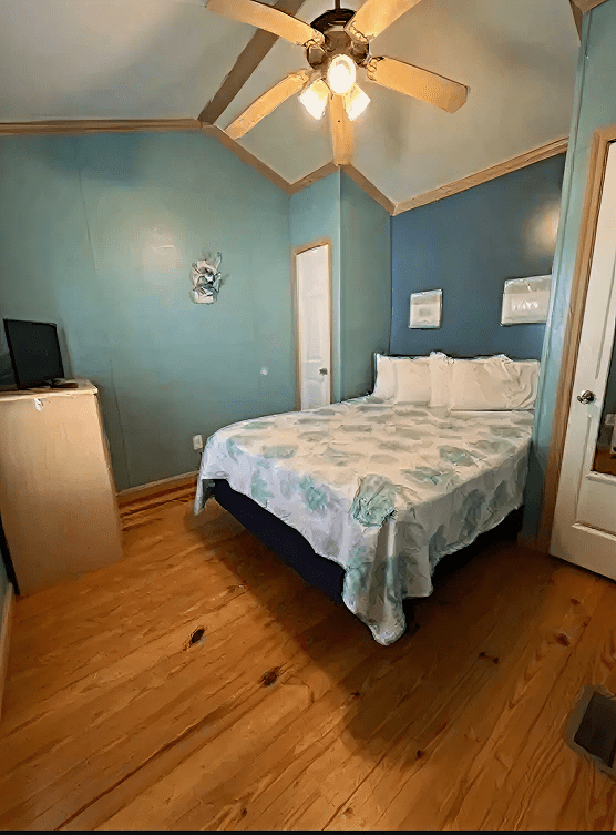 Cozy bedroom with blue walls and decor.