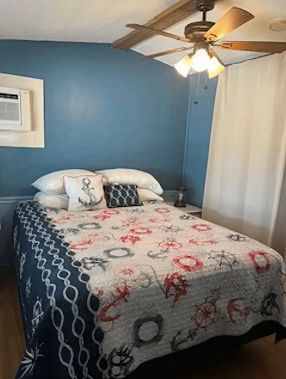 Cozy bedroom with nautical bedding and fan