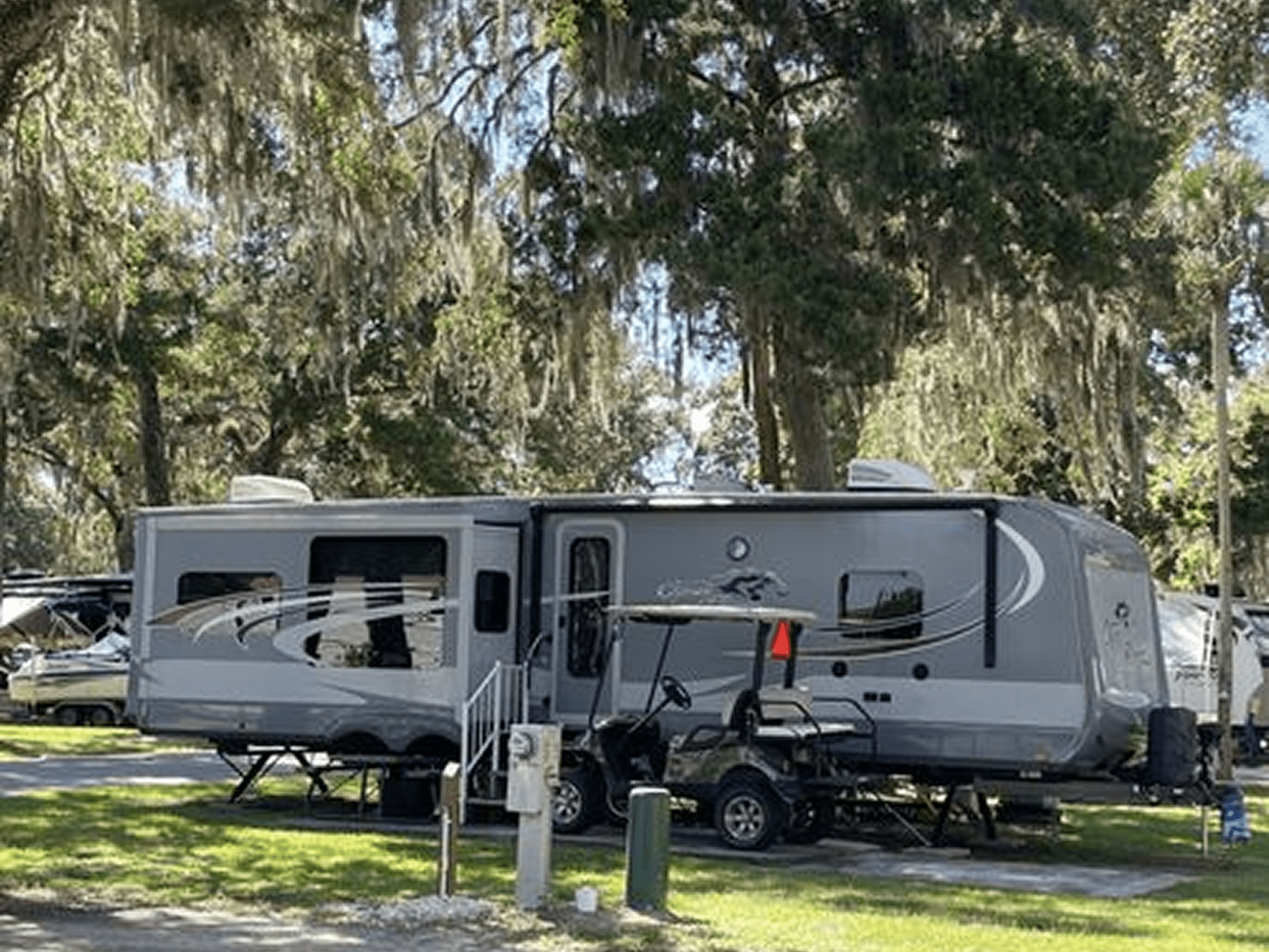 Camper with golf cart beside it